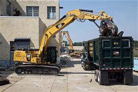 Demolition: A Caterpillar 336F loads a dump trailer with processed material.